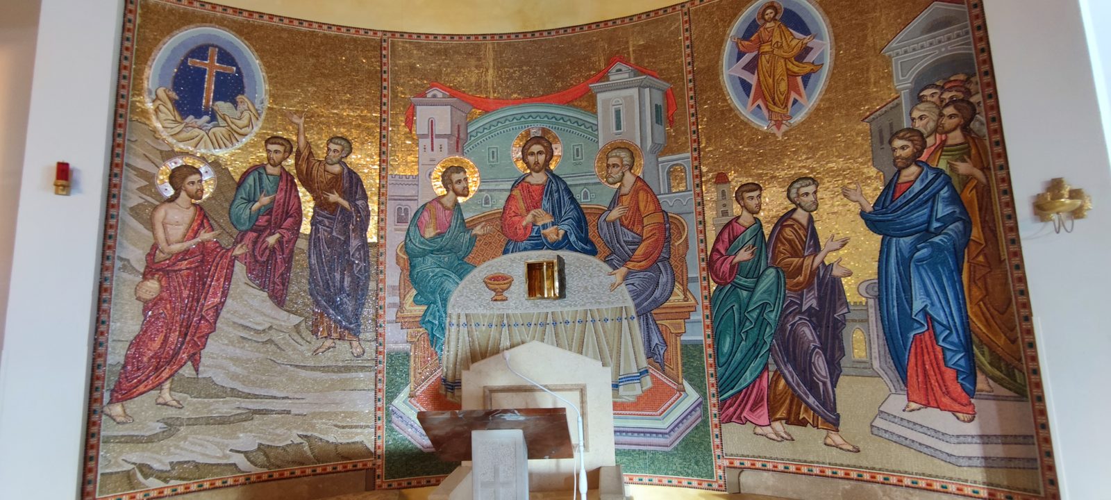 Chiesa Santa Maria Goretti Mosaico absidale a fondo oro con Cristo a tavola tra gli apostoli, affiancato dalle scene di Cristo sulle acque e della risurrezione, nella Chiesa di Santa Maria Goretti