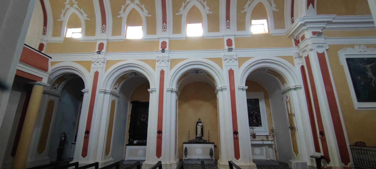 Chiesa Madonna SS. del Rosario Parete laterale con tre cappelle sotto gli archi, la statua di un santo domenicano nella cappella centrale e le finestre alte sopra la cornice, nella Chiesa della Madonna SS. del Rosario
