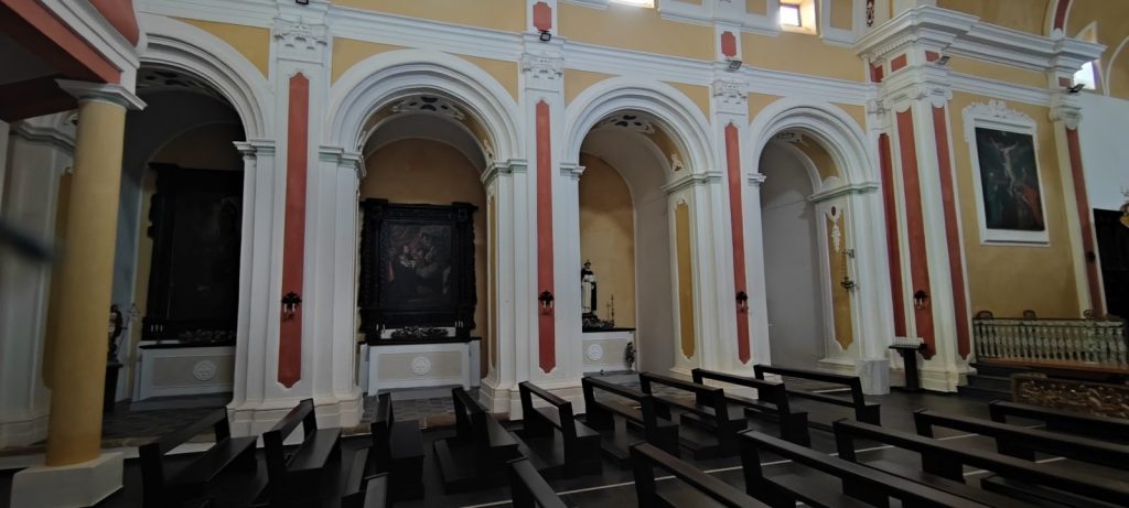 Fila di cappelle laterali sotto archi a tutto sesto, con le tele sopra gli altari e i banchi scuri in primo piano, nella Chiesa della Madonna SS. del Rosario