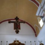 Home Crocifisso ligneo dipinto sospeso sull'arco del presbiterio, sotto la volta gialla, nella Chiesa della Madonna SS. del Rosario