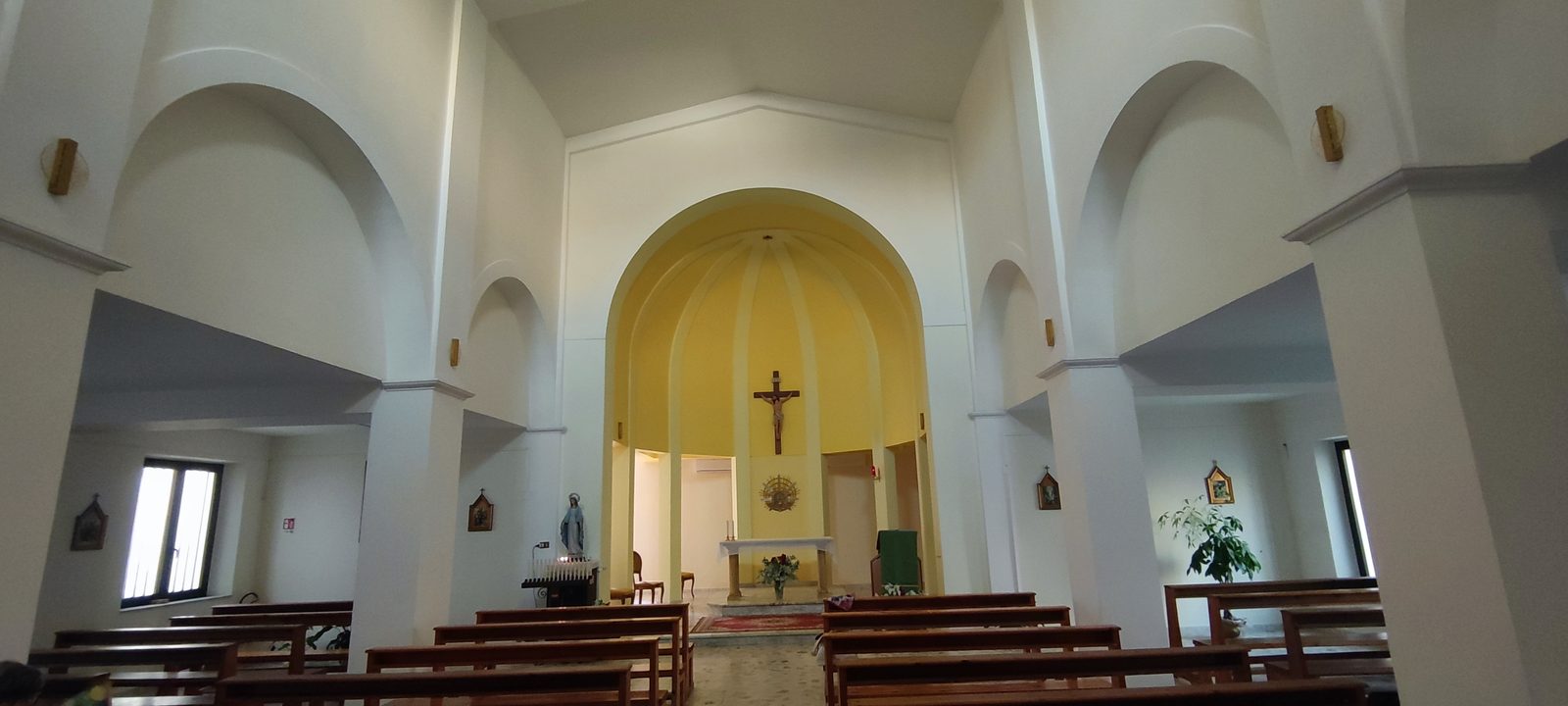Chiesa del Santissimo Sacramento Il presbiterio con l'abside gialla a spicchi, il crocifisso ligneo e l'ostensorio raggiato dorato sopra l'altare in pietra, nella Chiesa del Santissimo Sacramento